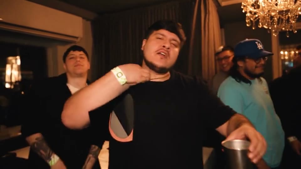 A guy in a black tee leads the room and his friends join in for the wave.